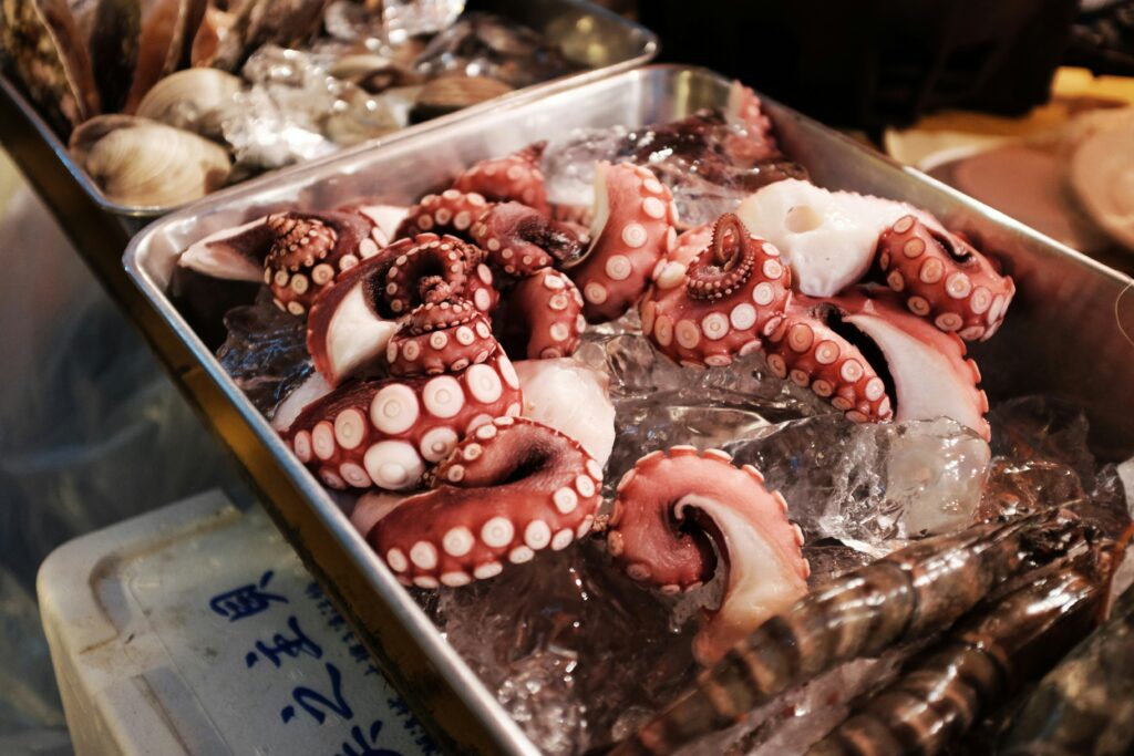 photo of octopus legs on a metal tray filled with ice