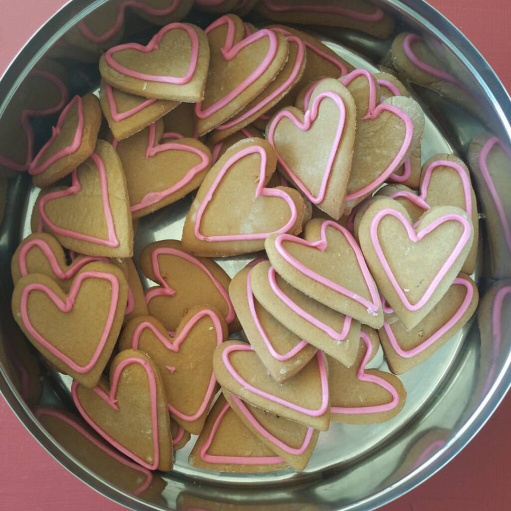 photo of a metal tin of heart shaped gingerbread biscuits with icing