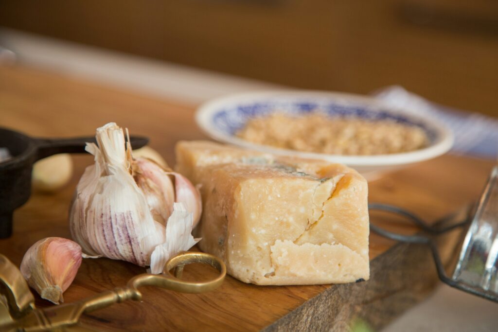 close up photo of a chunk of hard cheese and garlic