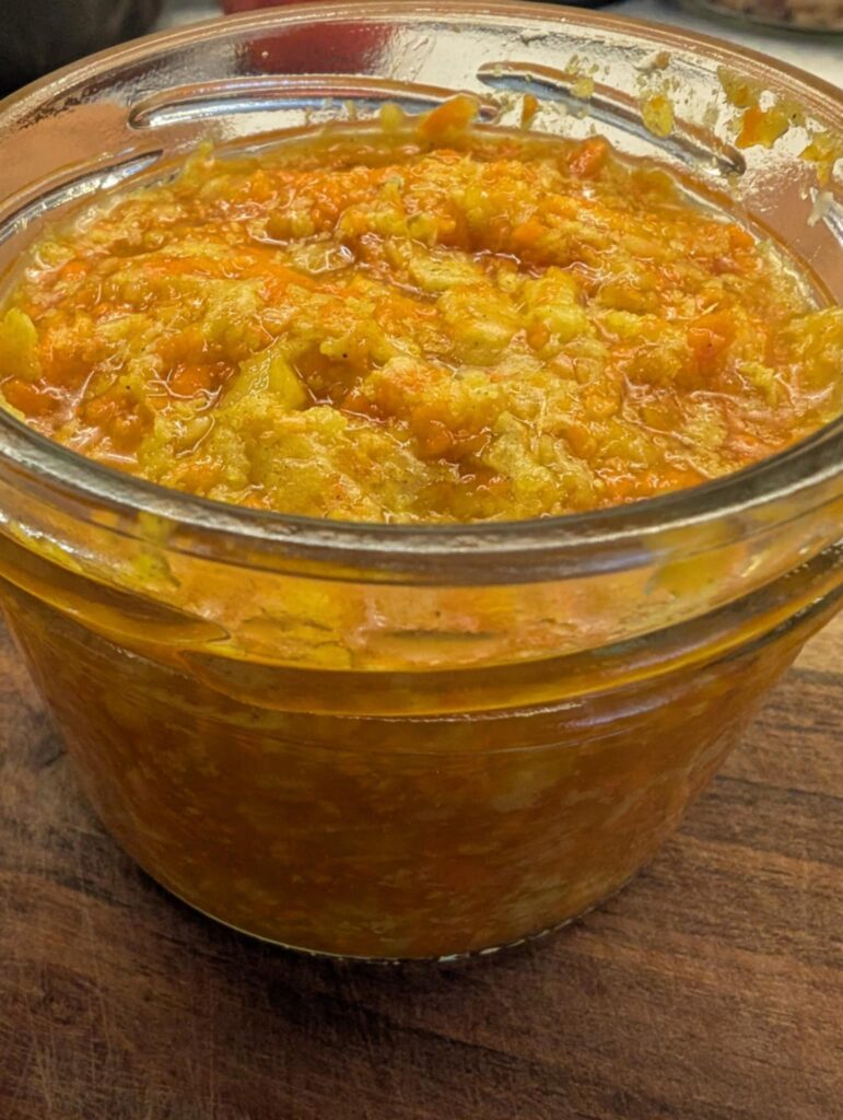 close up photo of a glass jar with an orange mush