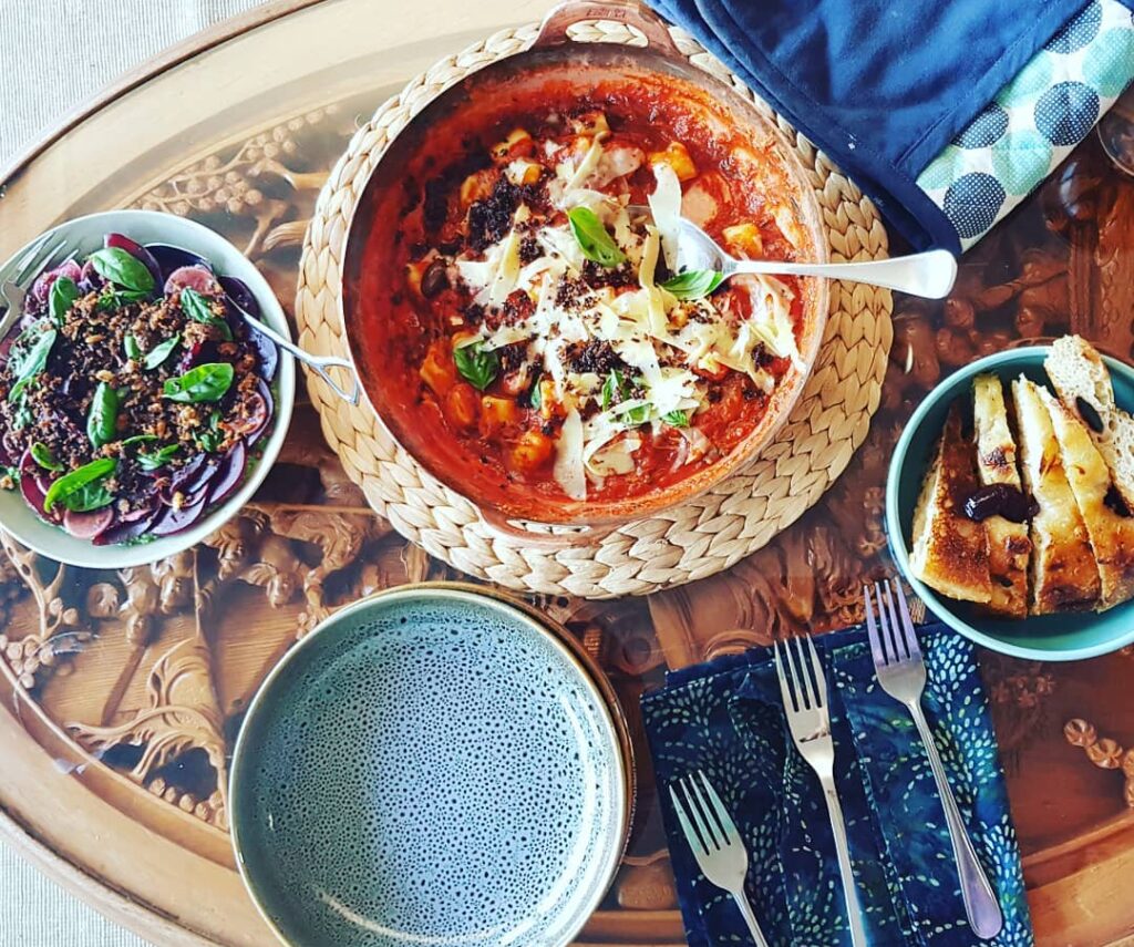 photo from above of a glass topped tables with food, plates and cutlery