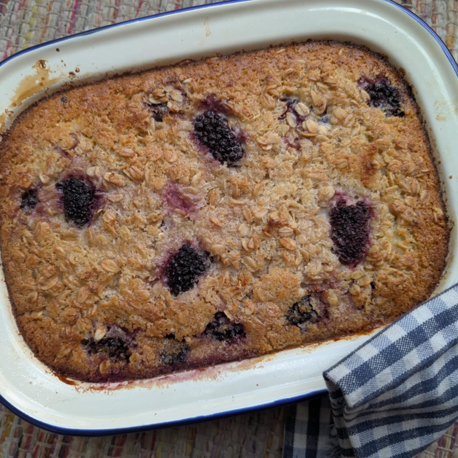 photo of a white ovenproof tin filled with cooked oats and berries