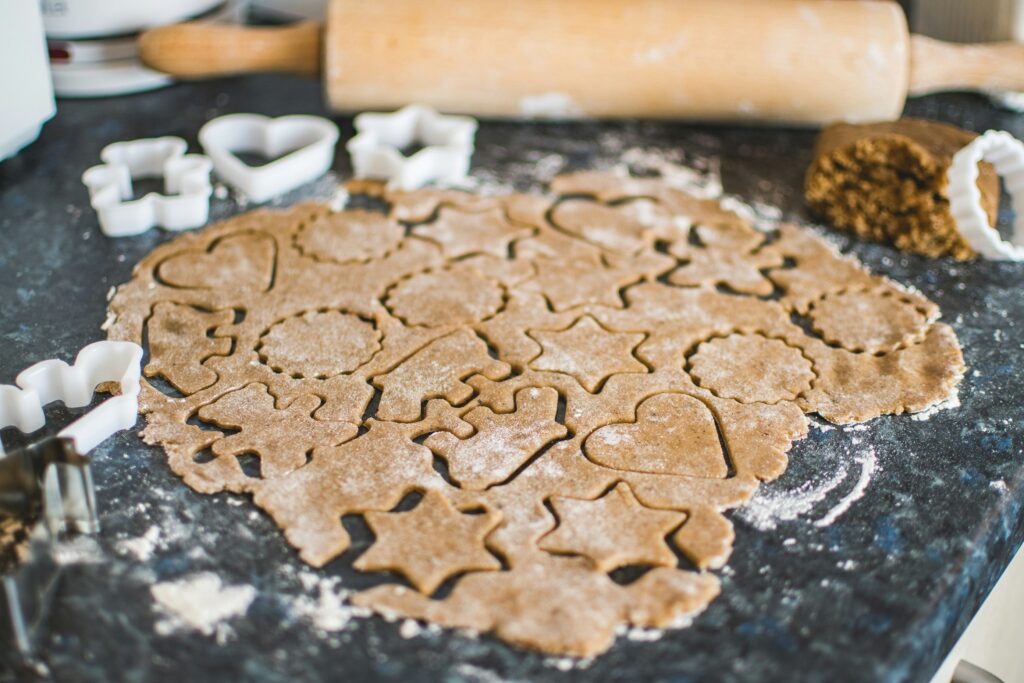 photo of gingerbread dough rolled out and shapes cut out