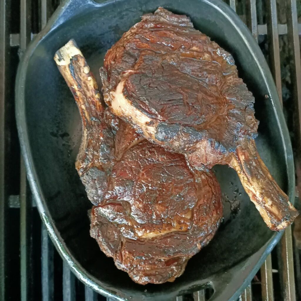 a black plate with two cooked steaks