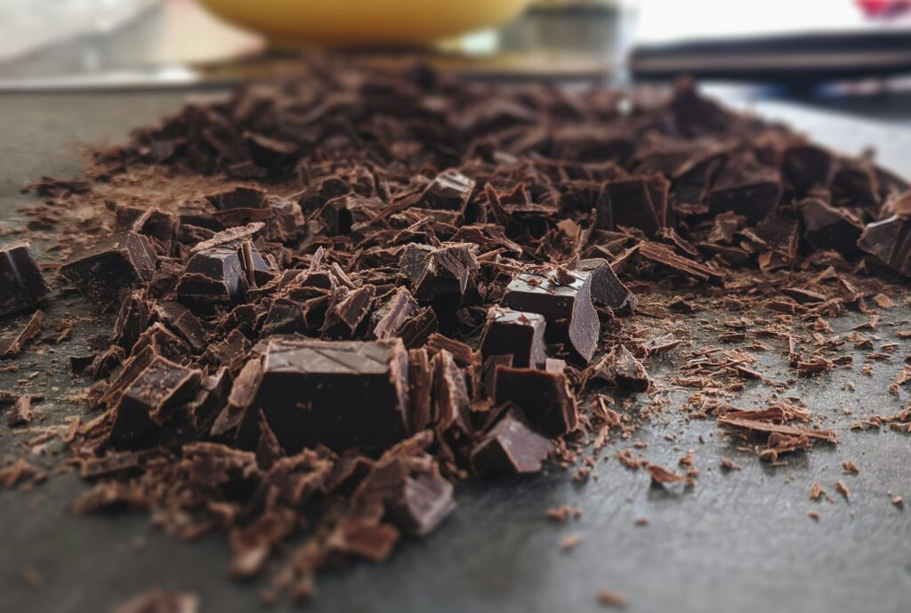 shards of dark chocolate chopped on a board and knife in background